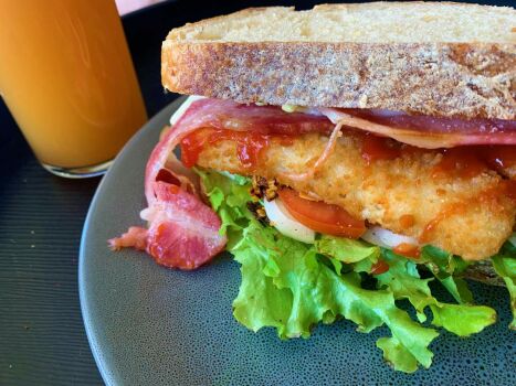 Oven baked fish, bacon, home grown lettuce, tomato, white onion, crunchy chilli, tomato sauce, kewpie mayo on home cut sourdough