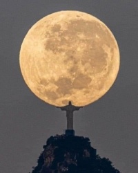 Leonardo Sens captured this beautiful photograph.   Christ the Redeemer holding the moon with both hands.