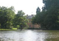 Tredegar House and Lake Tredegar House, seen from across the lake and surrounded by trees.