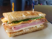 Club sandwich - Grilled sourdough, mayo, smoked ham, smoked turkey, bacon, Cheddar and Swiss cheese, lettuce, tomato, onion