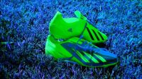 Green soccer shoes on blue grass . .