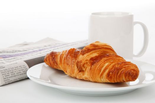 Croissant, newspaper, and tea
