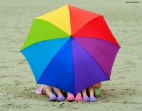 Children under colourful umbrella