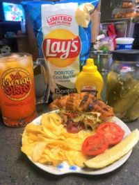 Corned Beef with Swiss, Sprouts and Homegrown Tomato on Toasted Croissant with Duke's Mayo and Yellow Mustard. Sided with Homemade Pickle and Doritos Cool Ranch Lays