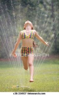 Picture of Girl running through lawn sprinkler on summer´s day