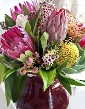 Happiness is :  A Variety of Proteas in a pretty Vase.