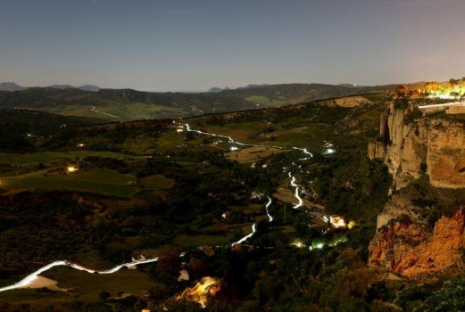 Runners leave headlamp trails as they make their way to the finish line at top right during the XXIII 101km international competition in Ronda Mountain Range in Spain