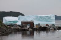 Fishing Stage dwarfed by massive Iceberg.