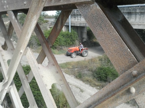 Tractor framed by bridge.