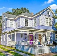 Purple and white Victorian Home with picket fence