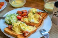 Eggs Benedict with homemade Sauce Hollandaise and cucumber-tomato salad
