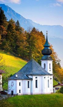 A traditional onion dome Roman Catholic church by Watzmann mountains at Berchtesgaden in Bavaria, Germany