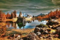 Cabin amidst red-hued trees on a cloudy day