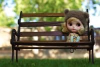 Cute Little Doll Sitting Alone On The Park Bench