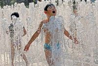 Children cool off in a fountain in Shanghai, China