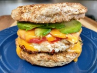 Egg Muffin Sandwich - Fried Egg, Tomato, Cheddar Cheese, Avocado, and Pesto Sauce in toasted Sprouted Wheat English Muffin