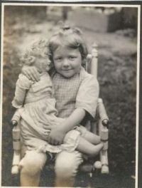 Vintage  Photo of A Smiling Child Holding Her Beloved Doll