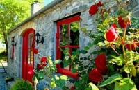 Rustic stone cottage, red windows and door