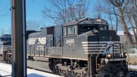 Norfolk Southern passing snow covered Amtrak station.