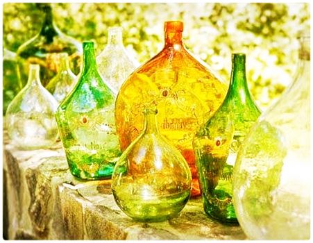 Coloured Glass Wine Bottles on a Stone Wall
