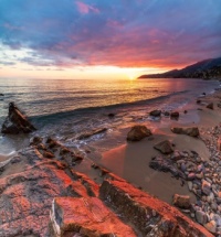 San Remo Riviera dei fiori Liguria Italy beach with rocks and colourful sky