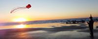Husband flying a kite at sunset on the Oregon Coast
